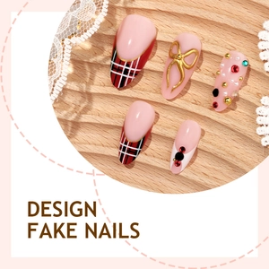Faux ongles amande roses avec carreaux rouges, nœuds dorés et strass de luxe