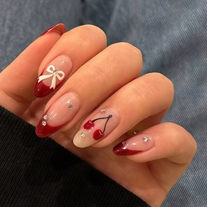 Almond almond cherry bow press-on nails with red french tips and 3D bow design