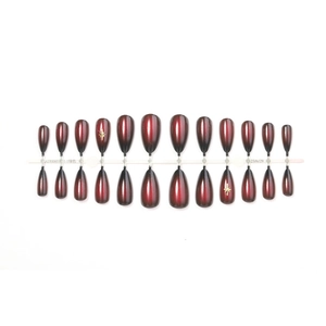 Retro red and black gradient press-on nails with golden star accents and stiletto shape