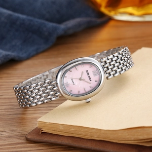 Détail du cadran ovale en nacre rose et du bracelet tressé en argent d'une montre quartz