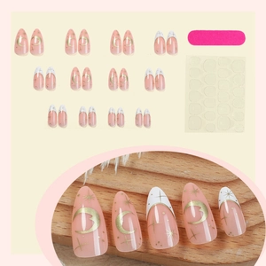 Faux ongles amande avec lunes dorées, étoiles et pointes french en rose nude