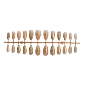 Almond-shaped press-on nails featuring nude gradient, gold lines and star patterns