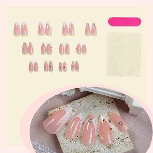French tip press-on nails set in nude pink with pearls and rhinestones, water drop shape