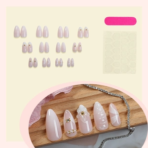 Almond-shaped press on nails in nude pink gradient with white flowers and pearls
