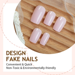 Glossy light pink press on nails in square shape on a rustic wooden background