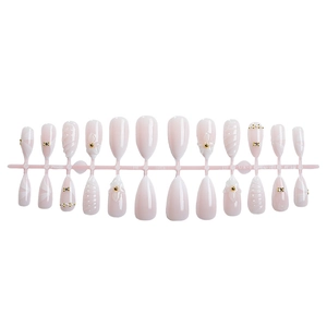 Almond press on nails with white ribbon flowers and pearls on pink display rack