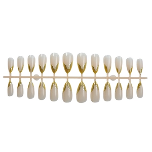 Detail view of 24pcs almond cat-eye fake nails with gold V-line French tips on a plastic rack