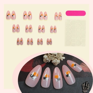 Halloween almond press-on nails with cute pumpkin and ghost patterns on nude base