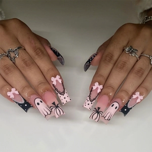 Long square Halloween press-on nails with pink base, black dots, and 3D bow accents