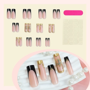 Long ballet press-on nails with black French tips, gold fluid lines and cross charms