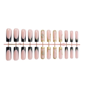 French tip press-on nails with black borders, gold crosses, and star art on square tips