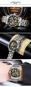 Detail of hollow black dial with golden mechanical gears on silver steel business watch