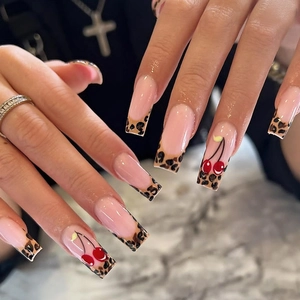 French leopard print long trapezoid press-on nails with cherry accents on marble background