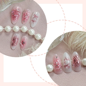 Faux ongles 3D roses avec cœurs strass, nœuds métalliques et perles sur fond nacré