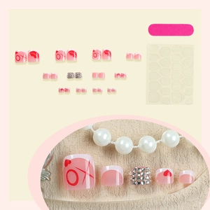 Faux ongles d'orteils français avec motifs de cœurs rouges et design XO