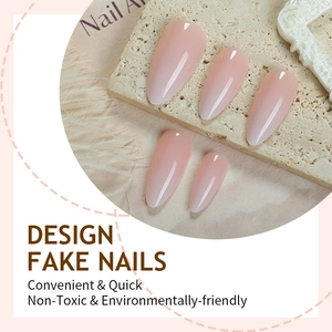 Elegant almond shape press-on nails with soft pink gradient on a stone display