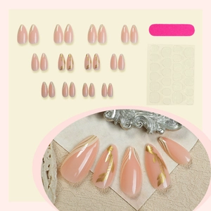 Almond-shaped nude press-on nails with gold leaf patterns and 24-piece manicure kit