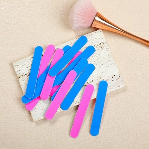 Close-up of double-sided blue and pink emery boards on a marble stone surface