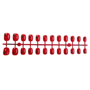 Short red press-on nails with dark star patterns and glossy finish, 24 piece set on a runner