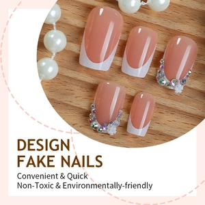 French tip press-on nails with sparkling rhinestones and floral 3D accents on nude base