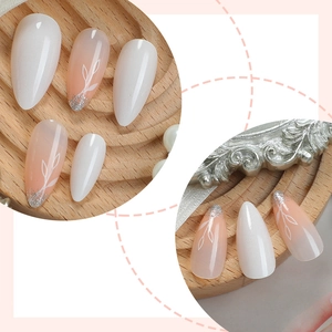 French almond press-on nails with white leaf art and silver glitter on pink gradient base