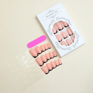 French tip press-on nail kit with nude pink base and black edges in elegant box
