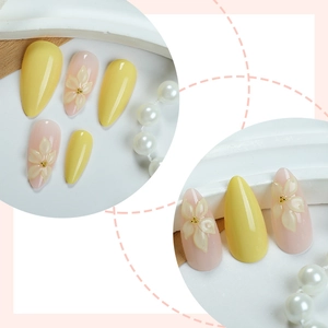 French yellow almond press-on nails with 3D floral accents and gold beads in a soft style