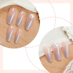 Long coffin press-on nails with nude base, silver glitter gradient and pearl accents