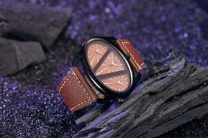 Macro shot of large black alloy case watch with brown leather strap and triple time zone dials