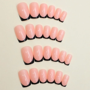 Pink press-on nails with black French tips in various sizes on a beige background