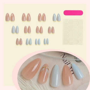 Almond French press-on nail kit with pink glitter, white petal designs, and gold accents