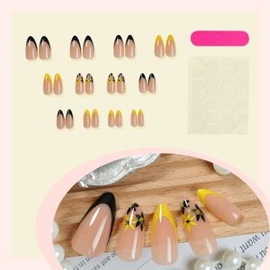 Faux ongles amande avec French manucure jaune et motifs floraux plus kit d'outils