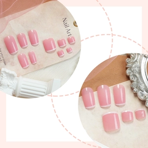 Pink and white French tip press-on nails with minimalist design on a display board