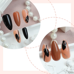 Unghie finte con glitter francesi e disegni a piuma nera in forma stiletto