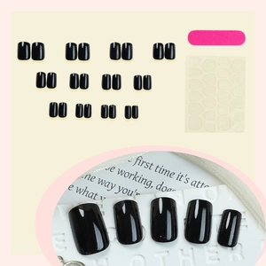 Glossy black press-on nail kit with 24 pieces, adhesive tabs and file in minimalist style