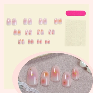 Gradient pink and orange press-on nails set with gold star accents and application kit