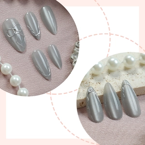 Silver grey cat eye press-on nails with 3D metal bow accents and almond shape
