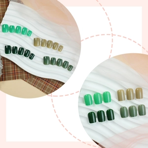 Short square press-on nails in various shades of green with a glossy finish