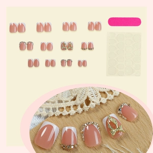 Short French tip press-on nails set with sparkling rhinestones and gold butterfly charms