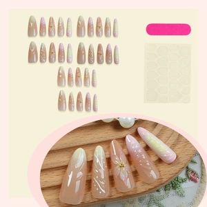 Long oval press-on nails with pink gradient, 3D white flowers, and pearl accents