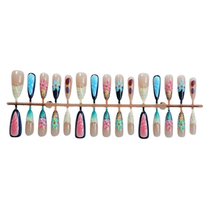 Long press-on nails with 3D floral designs, tiger print patterns, and colorful dots