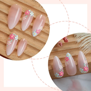 Pink almond press-on nails with delicate floral patterns and glossy jelly finish