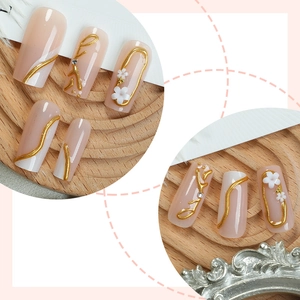 French press-on nails with nude pink gradient, 3D floral accents and gold trim