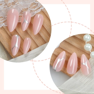 Faux ongles amande rose avec lignes géométriques argentées sur fond en bois naturel