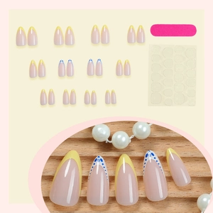 Almond-shaped French press-on nails set with yellow tips and blue floral patterns