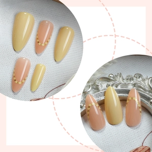 Faux ongles amande classiques en jaune et rose nude avec motifs à pois dorés