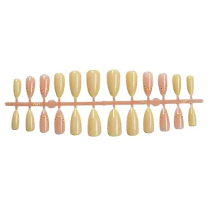 Faux ongles amande classiques de couleur beige et rose avec des motifs à pois dorés