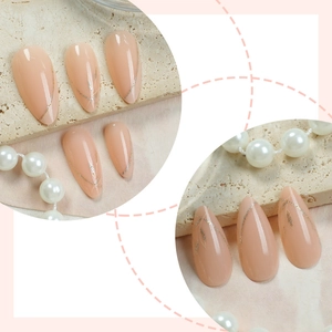 Almond-shaped nude pink press-on nails with silver glitter leaf designs and pearls