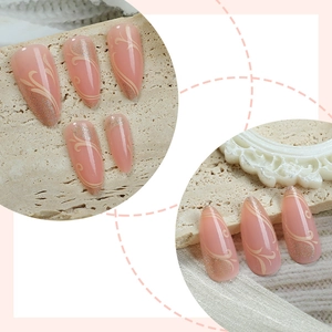 French almond press-on nails with white patterns and gold glitter on stone base
