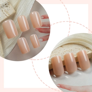 Glänzende nude-rosa Press-on-Nägel in kurzer quadratischer Form auf Stein- und Seidenhintergrund